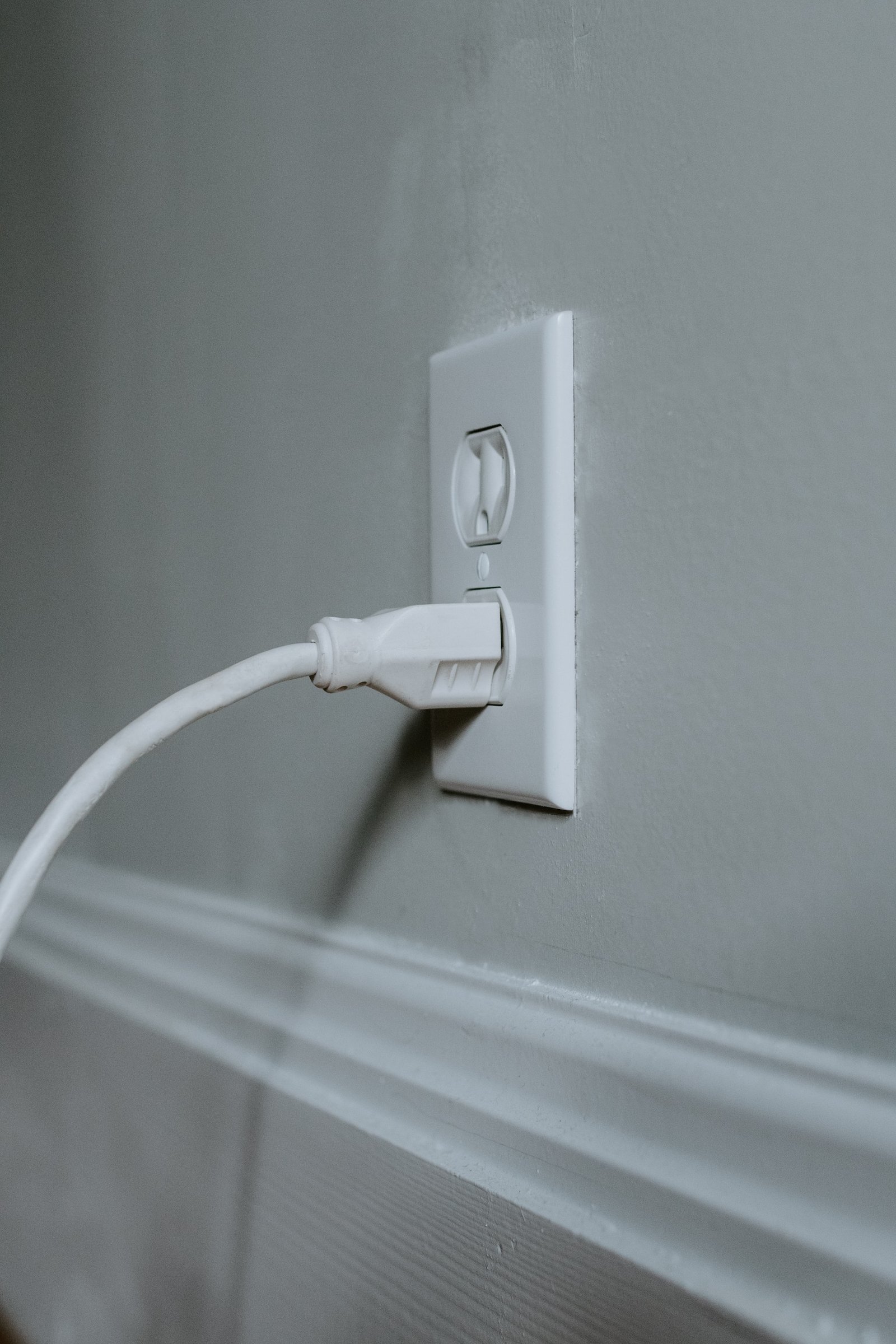 a picture of a power cord plugged into a wall outlet receptacle