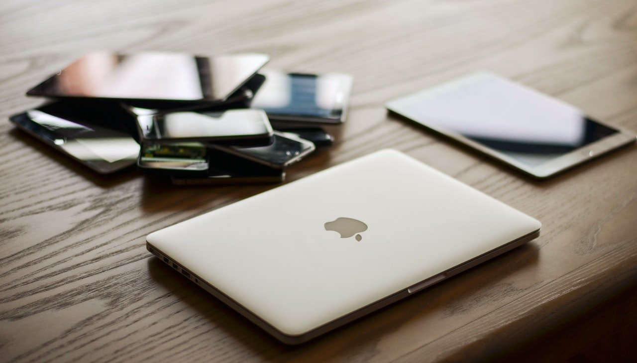 photo of a laptop and multiple smartphones and tablets on a table